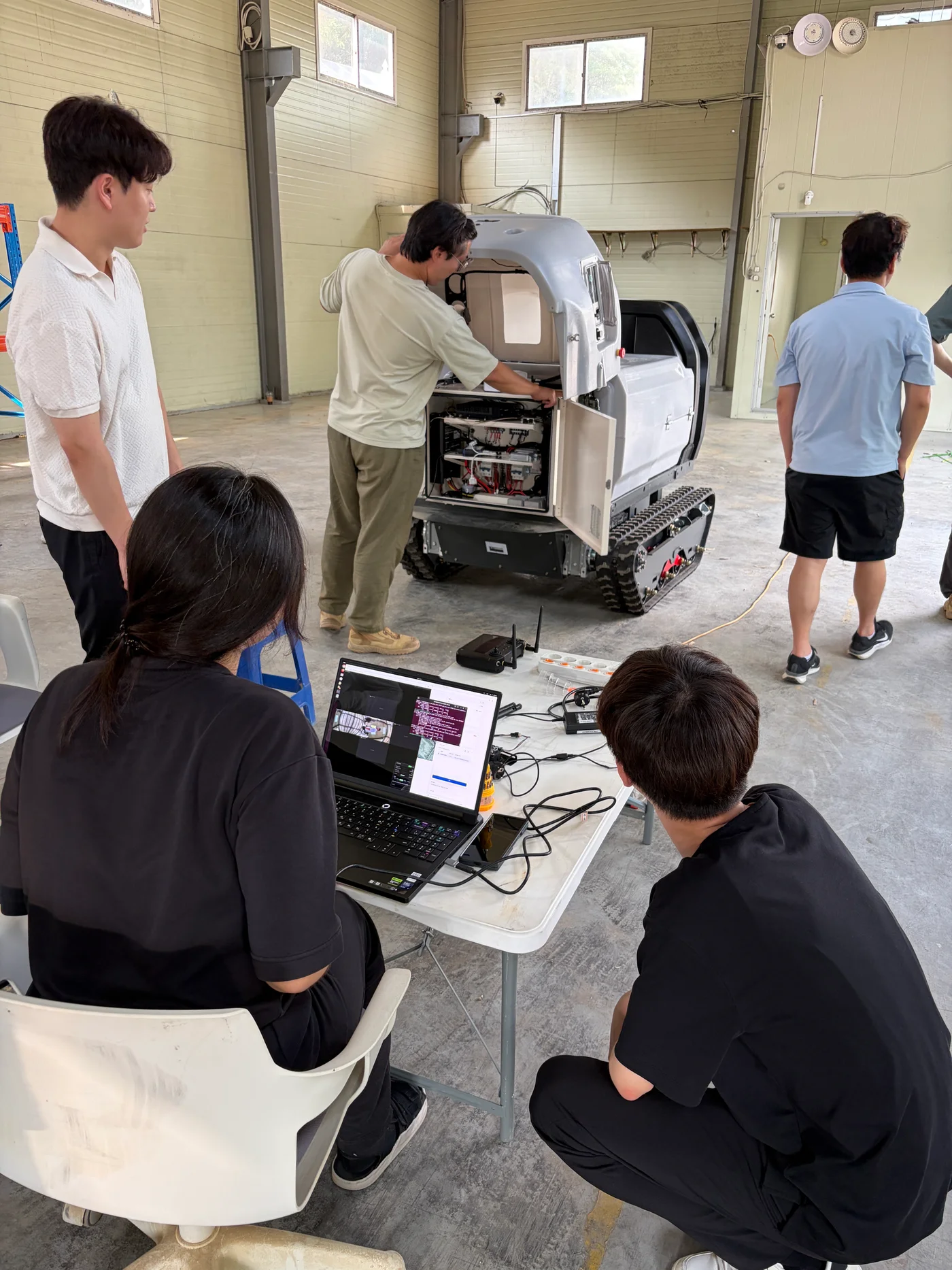 The team inspecting a GINT vehicle and working on laptops